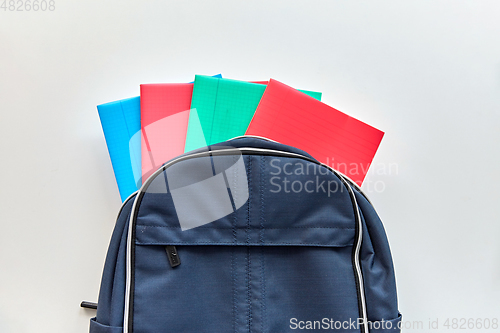 Image of school backpack with notebooks on table