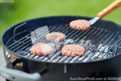 Image of close up of meat cutlets roasting on grill