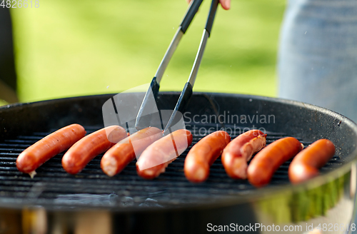 Image of meat sausages roasting on hot brazier grill