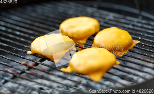 Image of close up of meat cutlet with cheese on grill