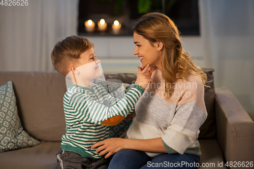 Image of happy smiling mother talking to her son at home