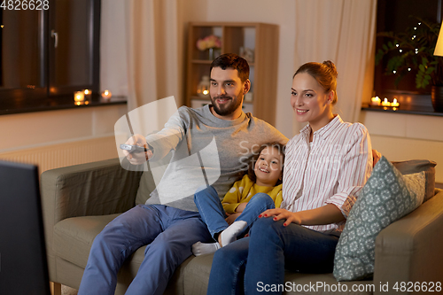 Image of happy family watching tv at home at night