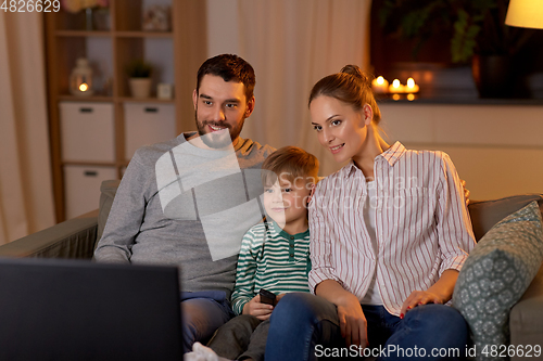 Image of happy family watching tv at home at night