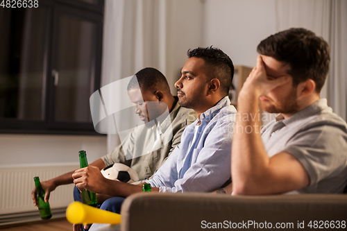 Image of sad friends with ball and vuvuzela watching soccer