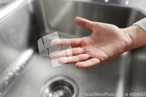 Image of close up of clean woman's hand over kitchen sink