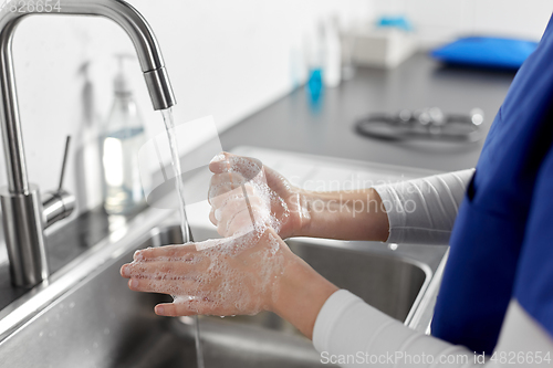 Image of doctor or nurse washing hands with liquid soap