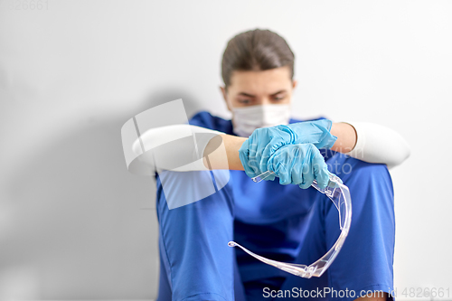 Image of sad doctor or nurse with goggles and face mask