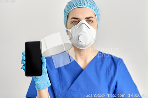 Image of doctor in goggles and face mask with smartphone