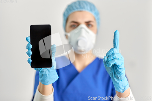Image of doctor in goggles and face mask with smartphone