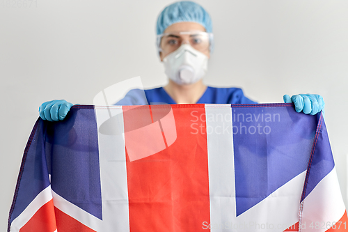 Image of doctor in goggles and mask holding flag of america