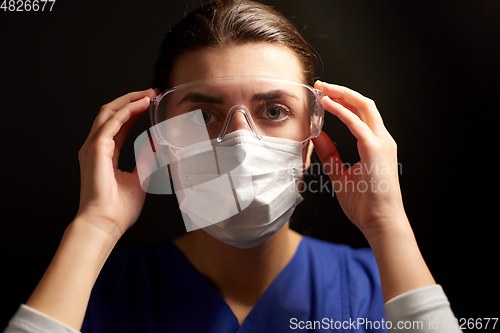 Image of female doctor or nurse in goggles and face mask