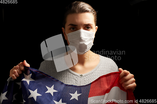 Image of sick woman in face mask holding flag of america