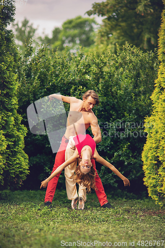 Image of beautiful modern ballet couple dancing in summer outdoors