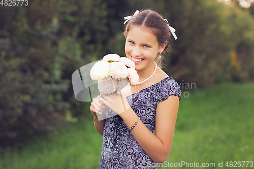 Image of beautiful teen age girl holding flowers