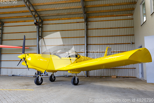 Image of outdoor shot of small plane standing in shed