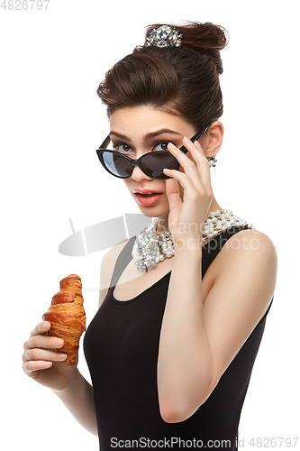 Image of beautiful young woman in retro style with croissant