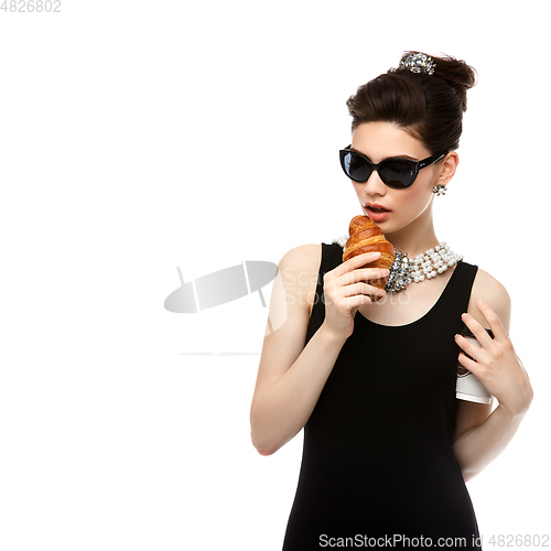 Image of beautiful young woman in retro style with croissant