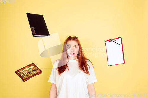 Image of Caucasian young woman\'s portrait on yellow background, too much tasks