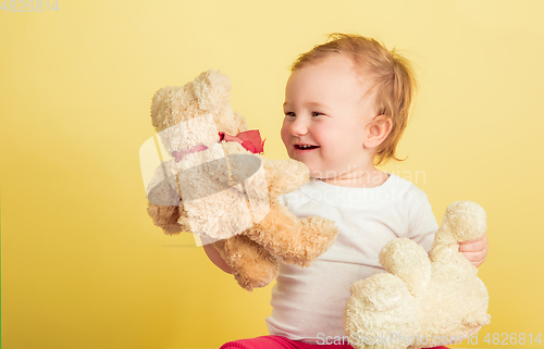 Image of Caucasian little girl, children isolated on yellow studio background