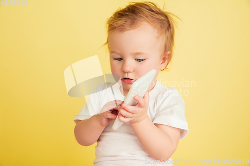 Image of Caucasian little girl, children isolated on yellow studio background