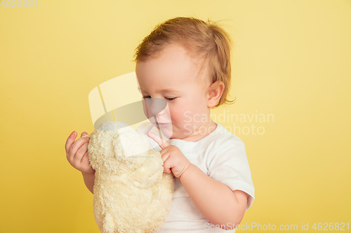 Image of Caucasian little girl, children isolated on yellow studio background