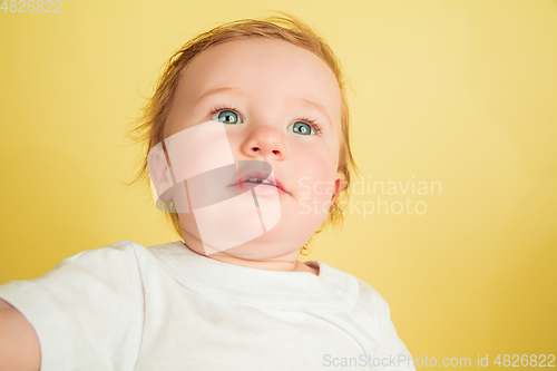 Image of Caucasian little girl, children isolated on yellow studio background