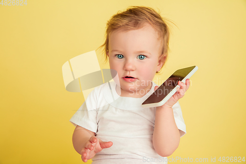 Image of Caucasian little girl, children isolated on yellow studio background