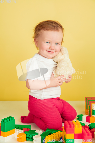 Image of Caucasian little girl, children isolated on yellow studio background