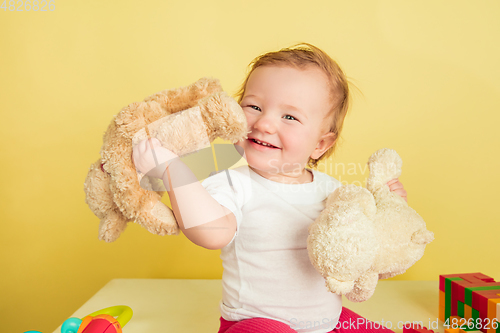 Image of Caucasian little girl, children isolated on yellow studio background