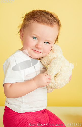 Image of Caucasian little girl, children isolated on yellow studio background