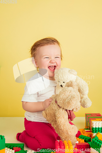 Image of Caucasian little girl, children isolated on yellow studio background