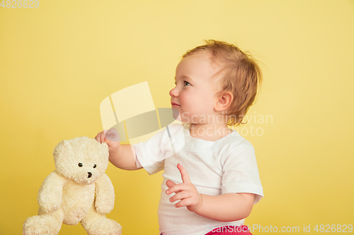 Image of Caucasian little girl, children isolated on yellow studio background