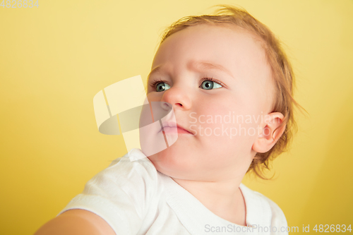 Image of Caucasian little girl, children isolated on yellow studio background