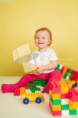 Image of Caucasian little girl, children isolated on yellow studio background