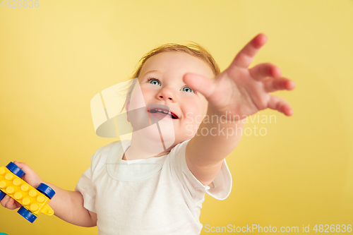 Image of Caucasian little girl, children isolated on yellow studio background