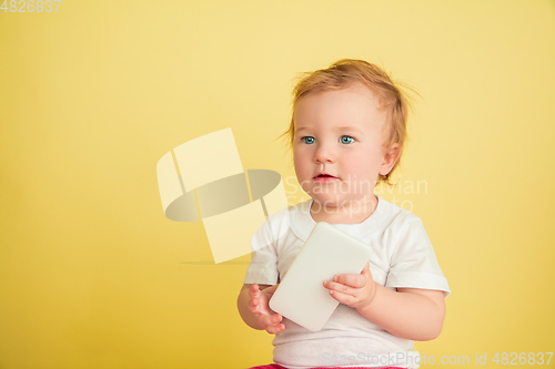 Image of Caucasian little girl, children isolated on yellow studio background