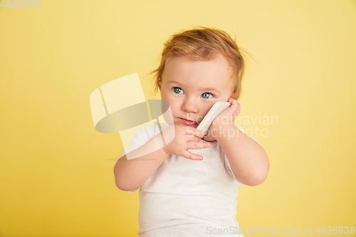Image of Caucasian little girl, children isolated on yellow studio background