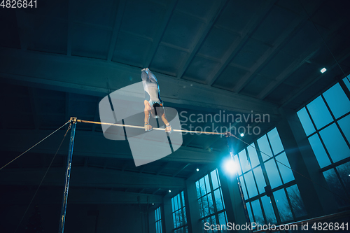 Image of Little male gymnast training in gym, flexible and active