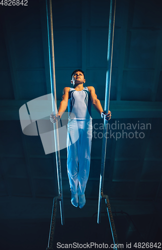 Image of Little male gymnast training in gym, flexible and active