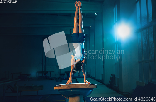 Image of Little male gymnast training in gym, flexible and active