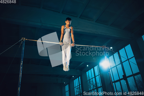 Image of Little male gymnast training in gym, flexible and active