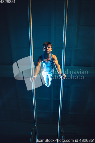 Image of Little male gymnast training in gym, flexible and active