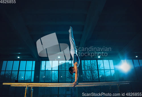 Image of Little male gymnast training in gym, flexible and active