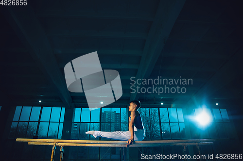 Image of Little male gymnast training in gym, flexible and active