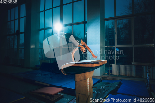 Image of Little male gymnast training in gym, flexible and active