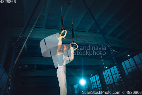 Image of Little male gymnast training in gym, flexible and active