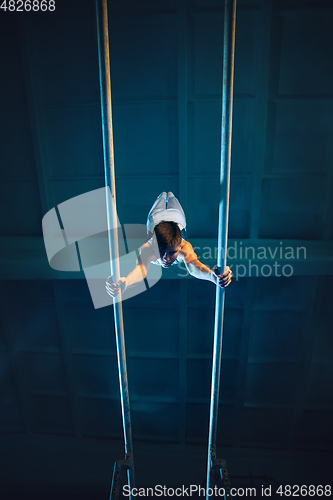 Image of Little male gymnast training in gym, flexible and active