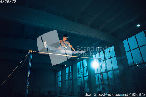 Image of Little male gymnast training in gym, flexible and active