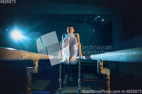 Image of Little male gymnast training in gym, flexible and active