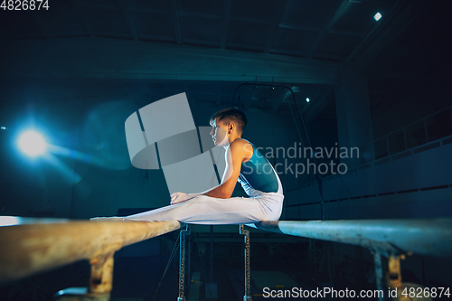 Image of Little male gymnast training in gym, flexible and active